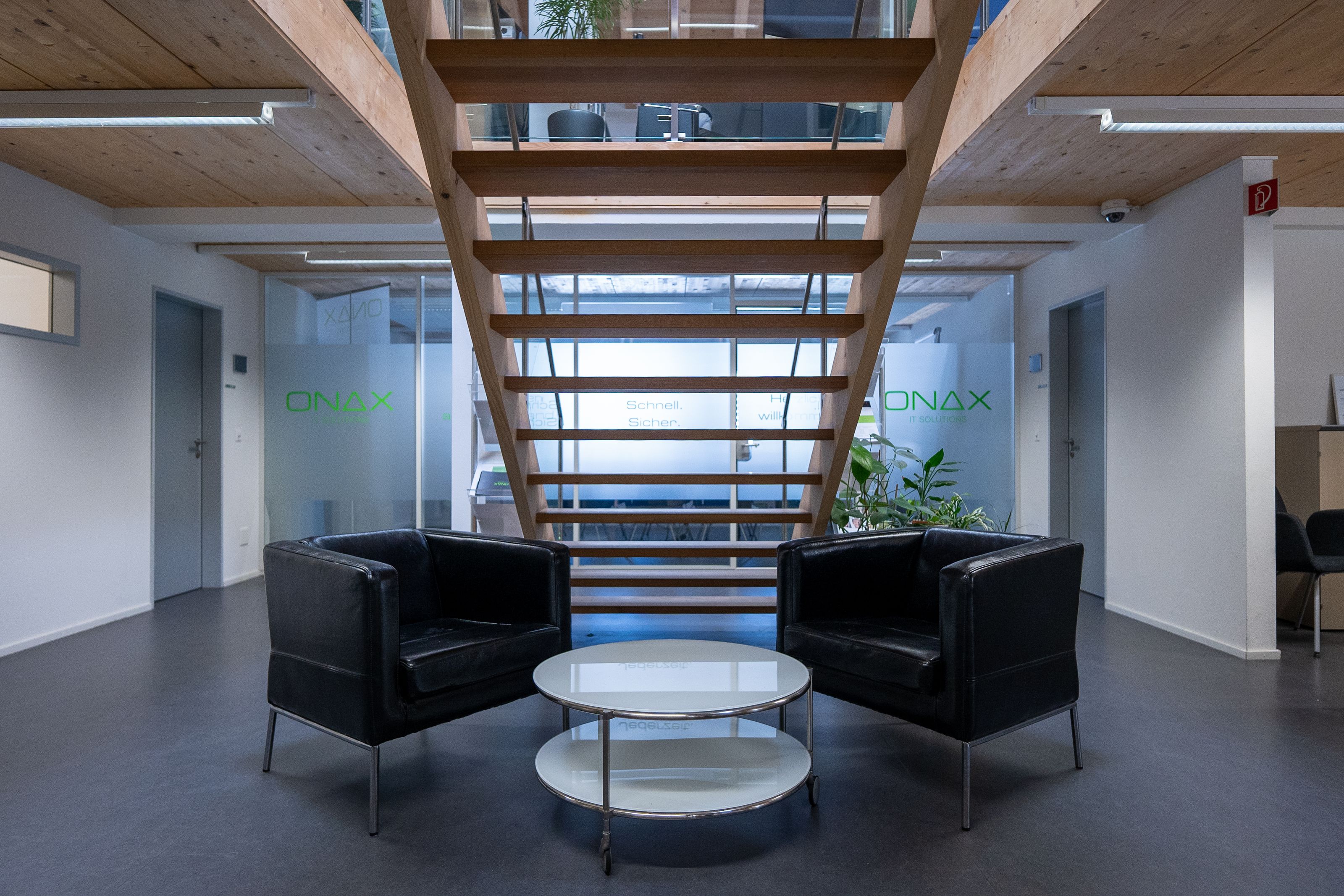 Moderner Empfangsbereich der Kanzlei mit Treppe